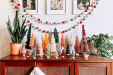 10 a chic credenza with colorful bottle brush Christmas trees, colorful felt garlands and a polka dot stocking