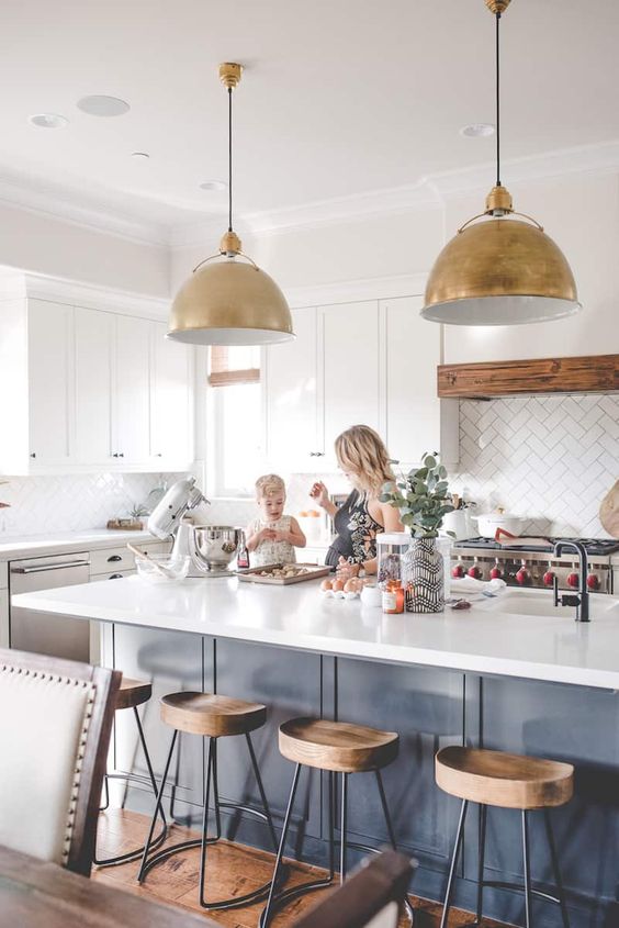 these amazing gold pendant lamps over the kitchen island highlight the style of the space and add glam and chic to it