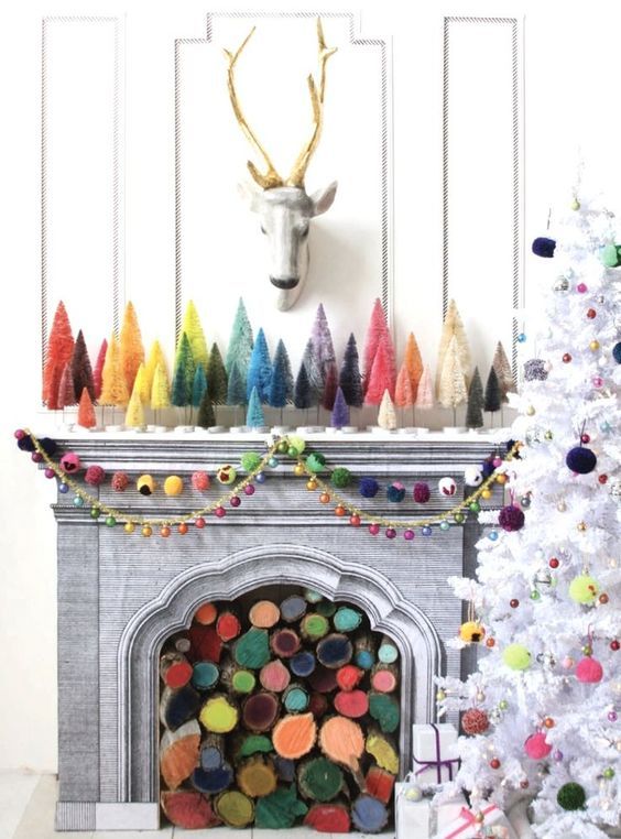 a fireplace filled with colorful firewood and matching bright bottle brush trees plus colorful felt garlands and bright pompoms on the tree