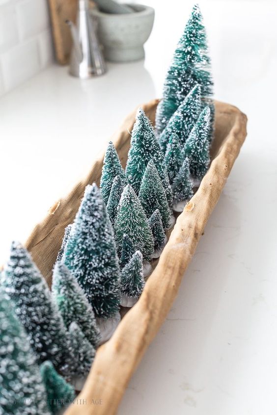 a long wooden tray with lots of green bottle brush trees is a pretty and lovely centerpiece for Christmas