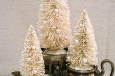 17 vintage tableware with faux snow and white bottle brush Christmas trees decorated with pearls make up adorable holiday decor