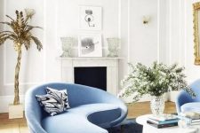 22 a charming living room with a curved blue sofa and matching chairs and a bold table that catch an eye