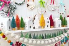 22 a super cheerful Christmas mantel with colorful bottle brush trees, bold wreaths and bold felt garlands is amazing
