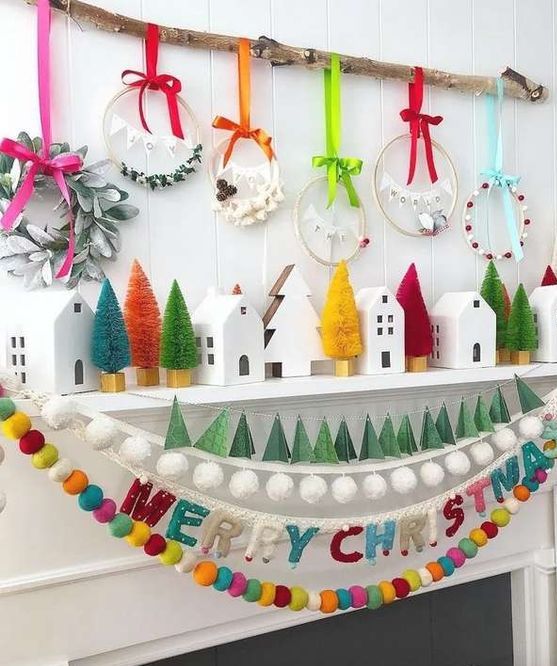 a super cheerful Christmas mantel with colorful bottle brush trees, bold wreaths and bold felt garlands is amazing