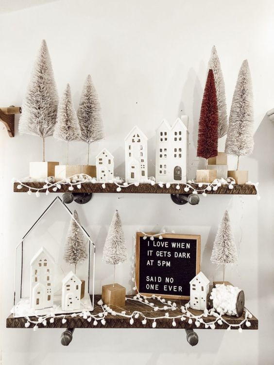 winter shelf styling with small white houses, pompoms, white and red bottle brush Christmas trees