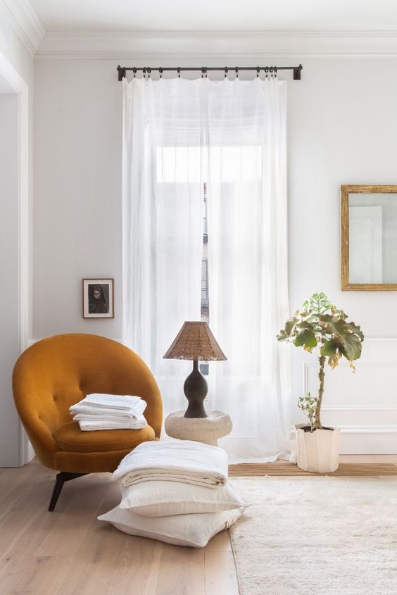 a lovely mustard-colored rounded chair will be a cozy and bold accent in your neutral space