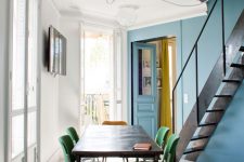 30 a catchy dining space with a stone blue accent wall, a black table and green retro chairs, a pendant lamp