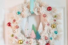 32 a white evergreen Christmas wreath decorated with colorful ornaments and colorful bottle brush Christmas trees