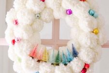 34 a white pompom Christmas wreat decorated with colorful ornaments and colorful bottle brush Christmas trees