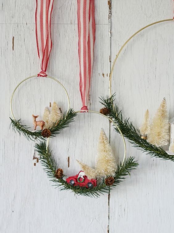 an arrangement of matching metal hoops with evergreens, pinecones, white bottle brush trees and little pinecones