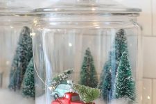 38 a Christmas terrarium made of a large jar with faux snow, bottle brush trees and a large truck plus lights around