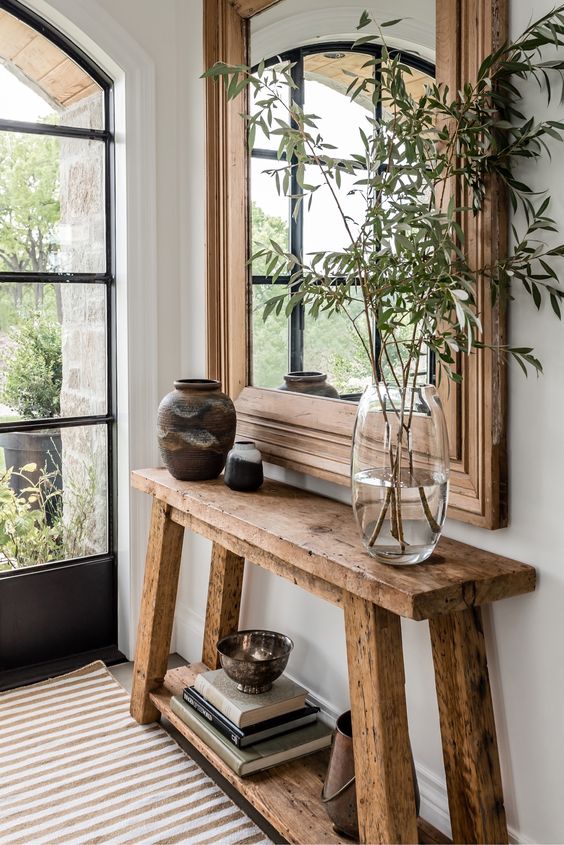 a reclaimed wood console table in the entryway gives it a warm and farmhouse feel easily and effortlessly