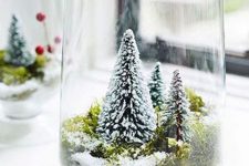 39 a large glass with moss and small bottle brush trees is a lovely idea of a snow globe with trees