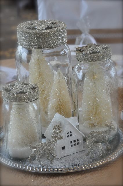 a silver tray with glitter animal figurines, a little house, jars with white glitter bottle brush Christmas trees