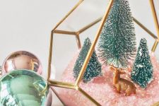 42 an elegant Christmas terrarium with pink faux snow, green bottle brush trees and a little deer figurine is chic and cute