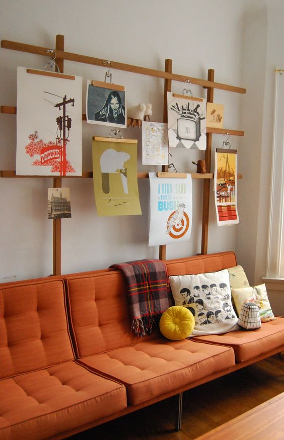 a plywood stand with lots of artworks hanging is a very creative idea, you may also hang some pots and planters here