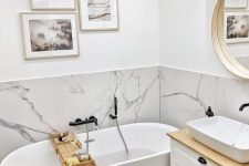 45 a small contemporary bathroom with a white marble backsplash and white furniture plus a gallery wall