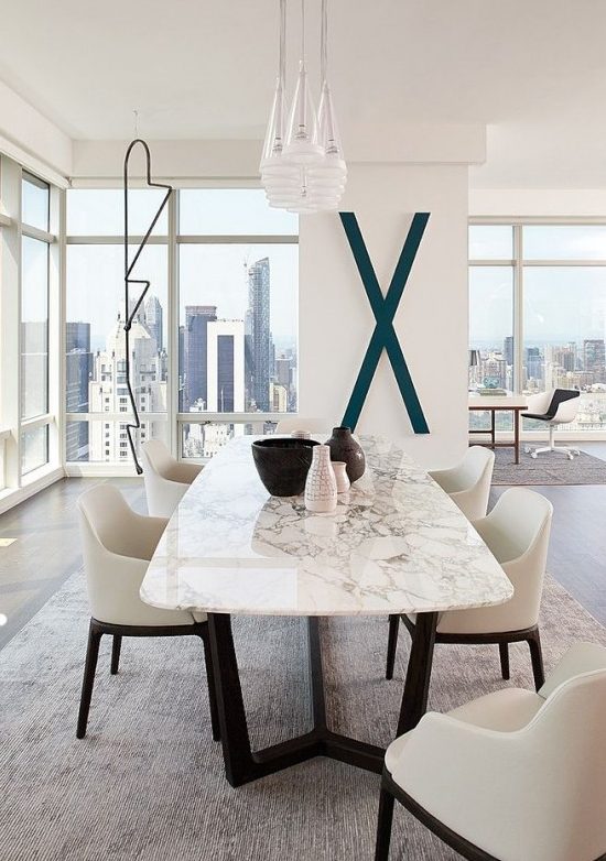 a contemporary luxurious dining table with a black base and a white marble tabletop for ultimate chic