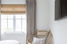 65 Roman shades and grey drapes over them add texture and interest to the space