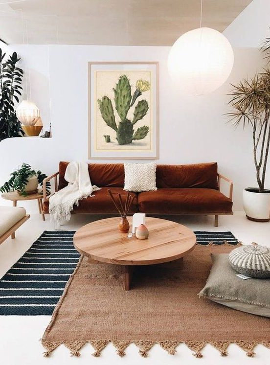 a striped rug, a woven one with tassels over it for a cool boho-inspired living room