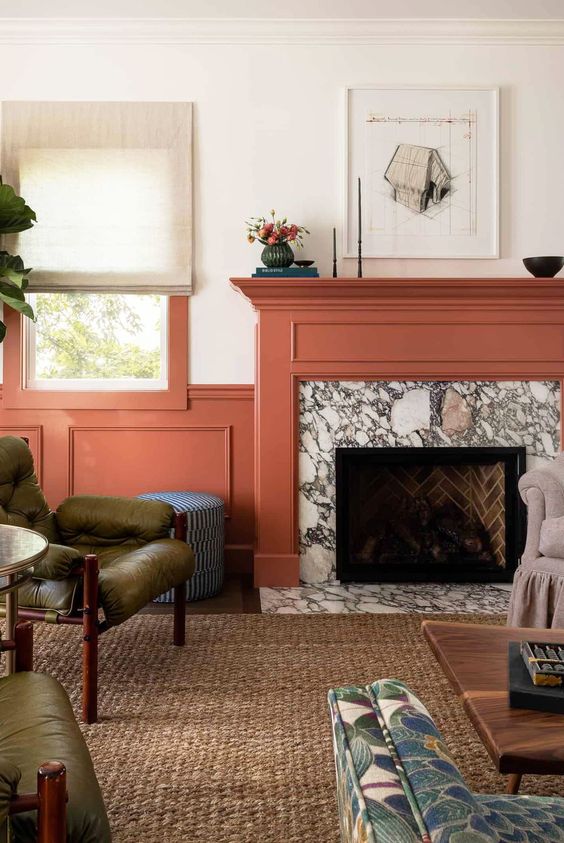 a-colorful-living-room-with-coral-paneling-a-marble-fireplace-with-a-coral-mantel-green-chairs-a-coffee-table-and-some-decor.jpg
