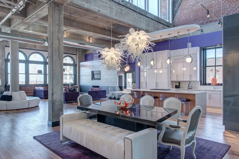 a fantastic refined open layout with periwinkle and white exquisite furniture, whimsical chandeliers and elegant floor lamps just wows