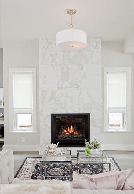 a-glam-white-living-room-with-a-white-marble-fireplace-neutral-seating-furniture-coffee-tables-and-some-decor.jpg