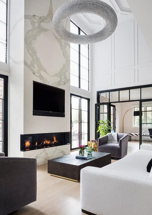 a luxurious living room with a large marble slab with a built-in fireplace and a TV is the centerpiece of the room