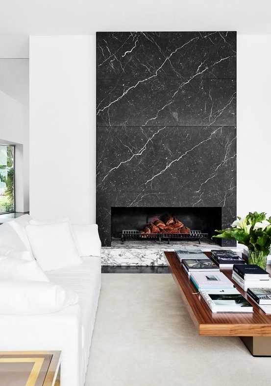 a luxurious living room with white and wooden furniture and a grey and white marble fireplace is a stylish and cool space