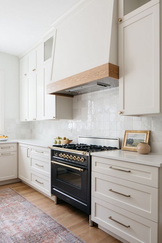 a modern farmhouse kitchen in soft creamy shades, with a white zellige tile backsplash and white stone countertops