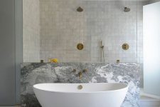 a neutral bathroom with a shower space clad with grey zellige tiles, with a bathtub space done with grey marble is wow