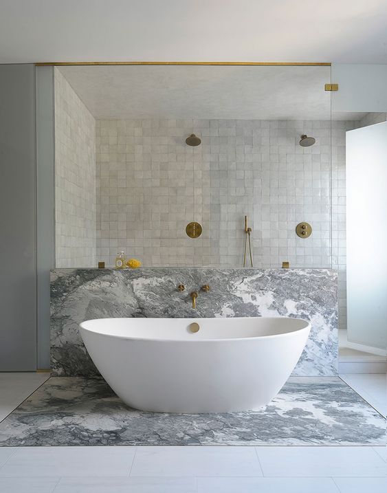 a neutral bathroom with a shower space clad with grey zellige tiles, with a bathtub space done with grey marble is wow