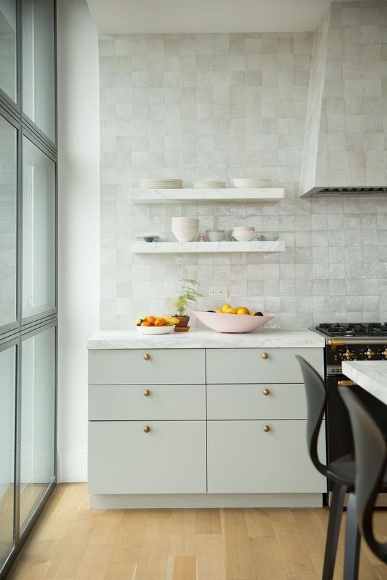 a plain dove grey kitchen with gorgeous mother of pearl zellige tiles covering the whole wall and the hood for more interest