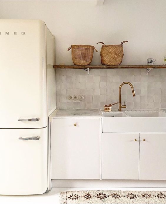 a sleek all-white kitchen made more eye-catchy with a grey zellige tile backsplash that adds both color and texture to the space