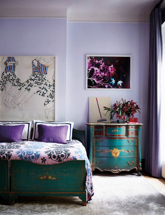 a sophisticated very peri bedroom with vintage teal furniture with painted florals, bold artworks and printed bedding