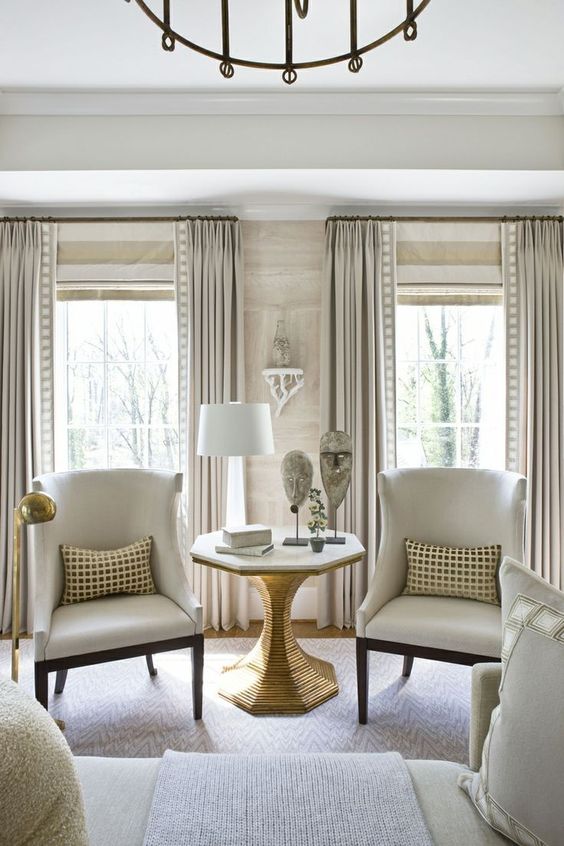 neutral striped shades and off white draperies with prints are a catchy idea for this neutral space and prints add chic and elegance