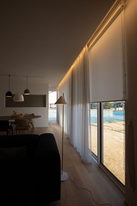 semi sheer white curtains add coziness and an airy feel to the room, while white blinds block sunshine and bring privacy