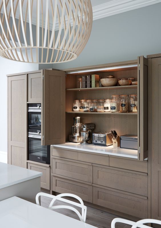 a beautiful and sleek stained wooden cabinet with small appliances hidden inside it, with built-in lights and bi-fold doors for comfortable using