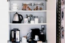 05 a home tea and coffee bar with all the necessary appliances and various cups and cookies hidden inside a kitchen cabinet