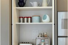 07 a kitchen cabinet with bi-fold doors is an ideal storage space for hiding all your appliances, especially those that you don’t use very often