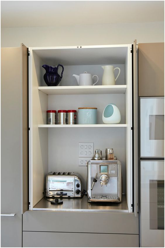 a kitchen cabinet with bi fold doors is an ideal storage space for hiding all your appliances, especially those that you don't use very often