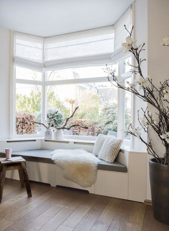 a lovely bow window with a windowsill daybed with pillows make up a lovely reading nook in the space