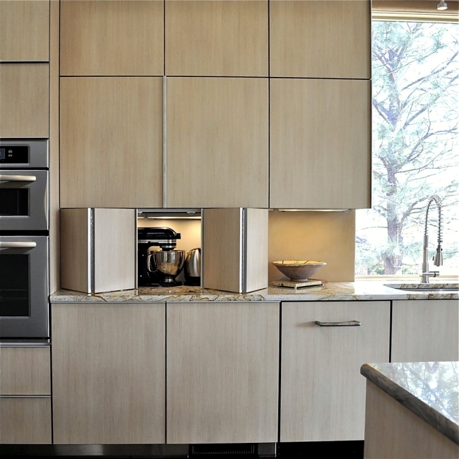 a sleek contemporary kitchen with lower cabinets featuring bi fold doors and lights inside to hide the appliances