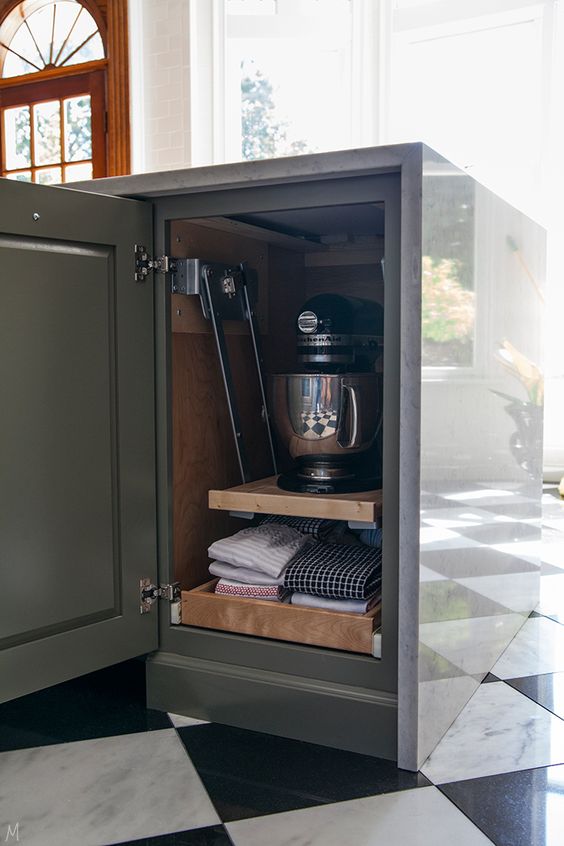 a small and narrow kitchen cabinet with retractable and lifting up shelves that hold kitchen appliances and kitchen towels