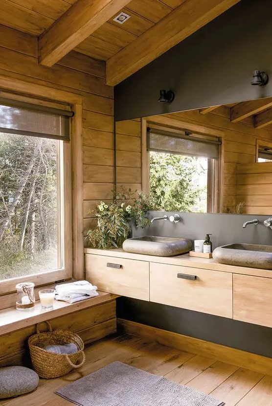 a contemporary bathroom fully clad with wood, with a large mirror, a wooden vanity and a window for a cool view