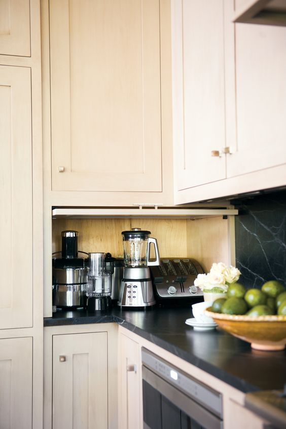 all the kitchen appliances placed inside a small cabinet with a garage style door for fast access anytime