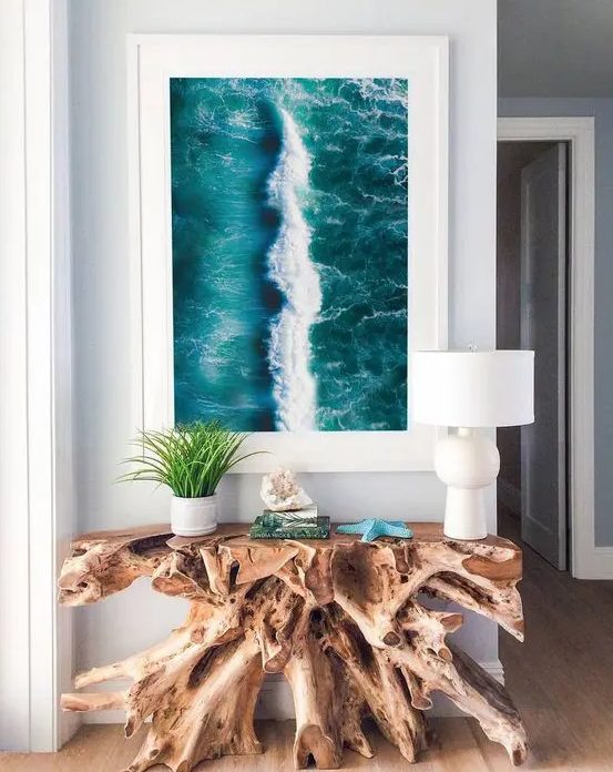 a gorgeous driftwood console table and an ocean print turn the entryway into a fantastic seaside space and they look wow