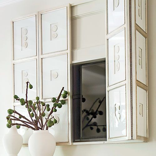 a TV hidden with bi-fold art panels that form a gallery wall is a lovely idea for any space