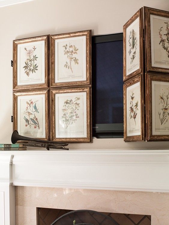 a TV over the fireplace hidden with a lovely gallery wall of vintage botanical posters is a lovely idea for a space with a vintage feel