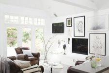 25 a modern neutral living room with brown leather furniture and a pretty black and white gallery wall that comprises a TV and a fireplace